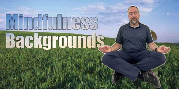 Man sitting in a field in a meditative pose.