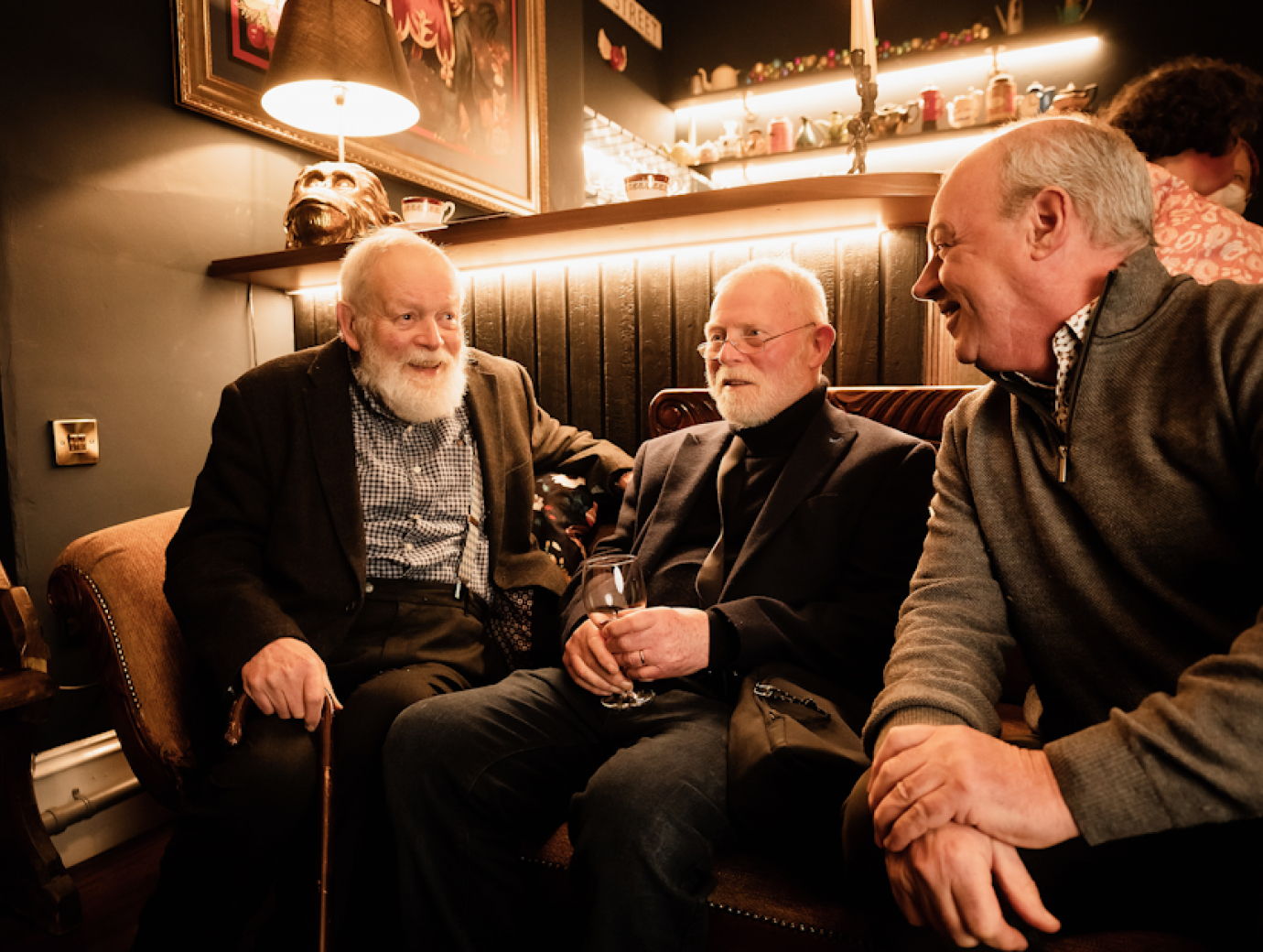 Poets Michael Longley and Frank Ormsby seated beside Arts Council Chair Liam Hannaway in a hotel lobby