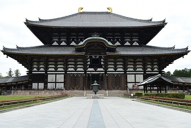 Large building with white and brown exterior, two roofs, and gold decoration