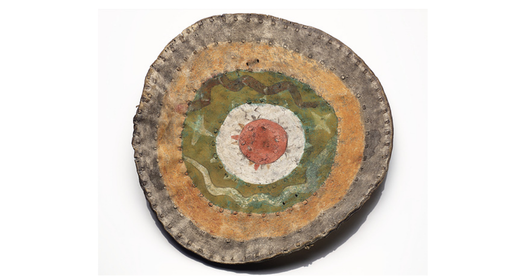 A circular shield with concentric rings of orange, green, white, and red.