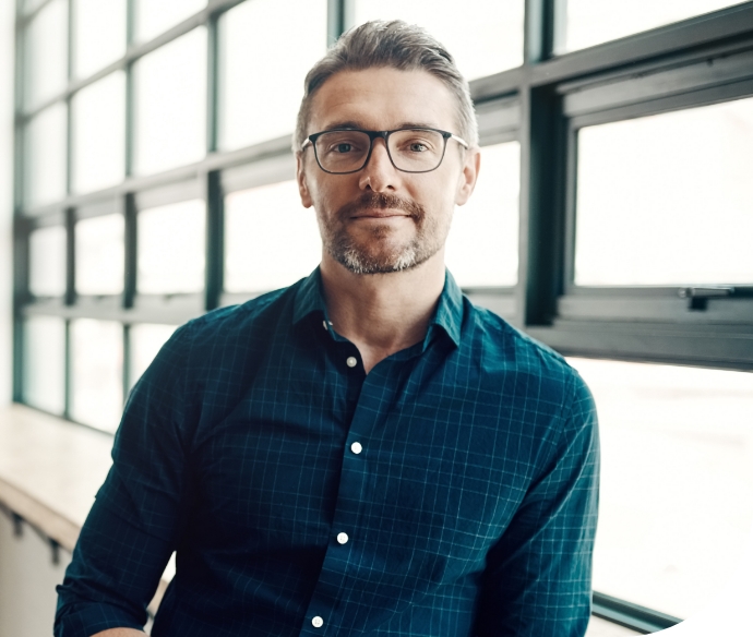 man in glasses standing new window