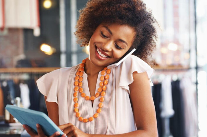 Woman talking on phone holding a tablet