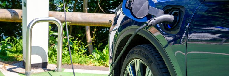 Electric car charging in parking lot at station on sunny day