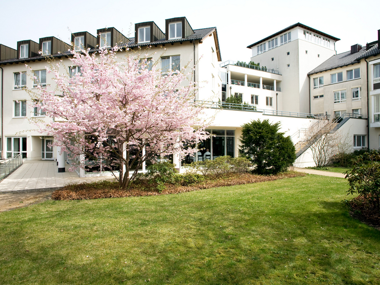 Hausansicht mit blühendem Baum - Immanuel Klinik Märkische Schweiz in Buckow