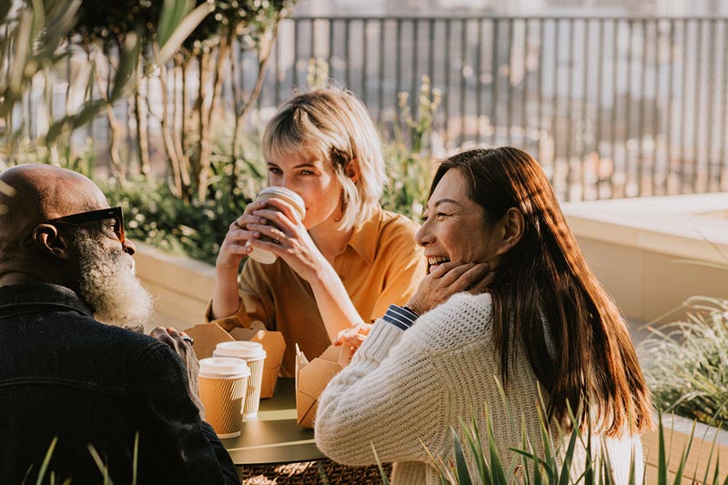 Three people having coffee outdoors