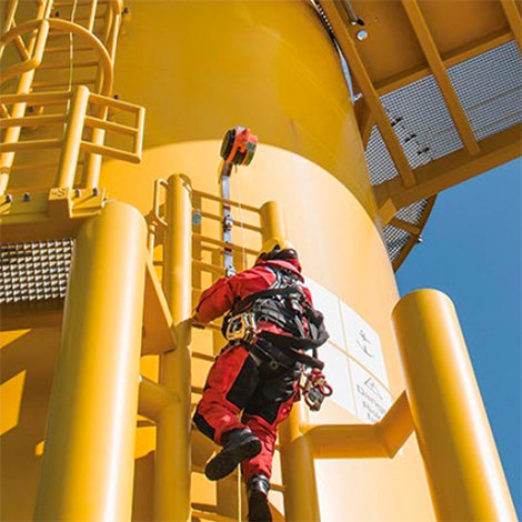 A worker climbing a ladder on a wind turbine.