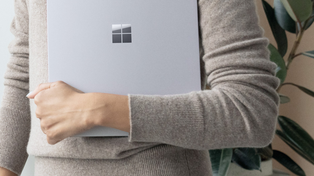 Image coupée d’une femme tenant un appareil Surface fermé avec un bras