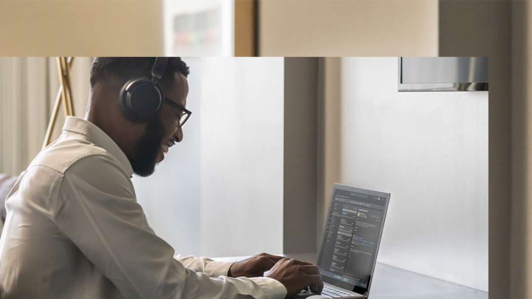 Vue de côté d’une personne travaillant sur un Surface Laptop 5 chez elle