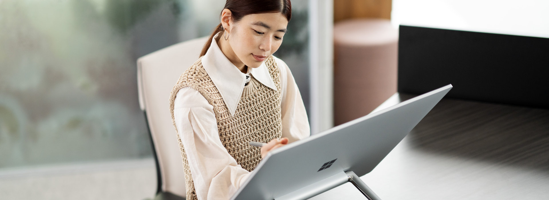 Une femme travaille sur son Surface Studio 2+ dans son bureau à domicile.