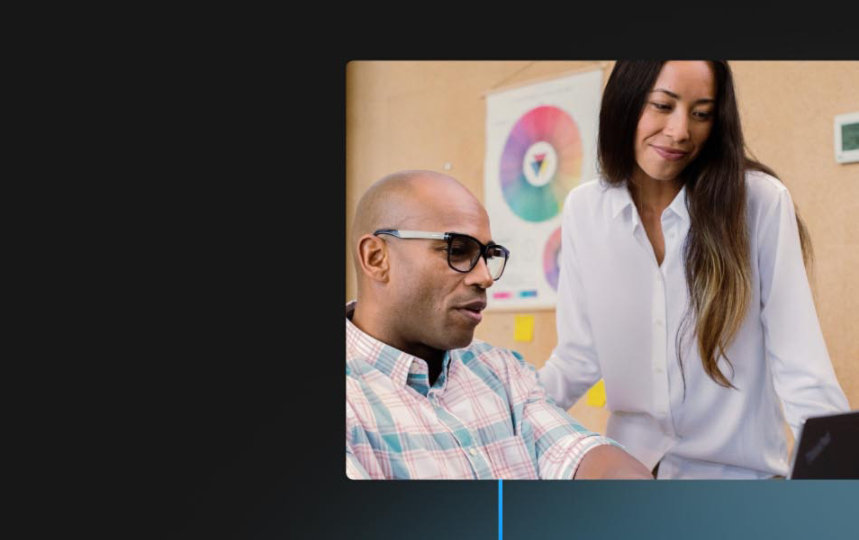 Two coworkers look at the screen of a Windows device