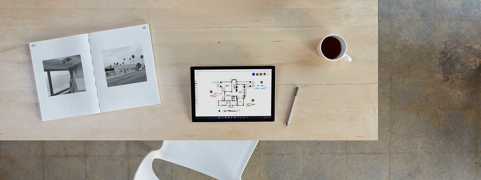 A top down view of a Surface device on a home desk detached from the keyboard  surrounded by accessories