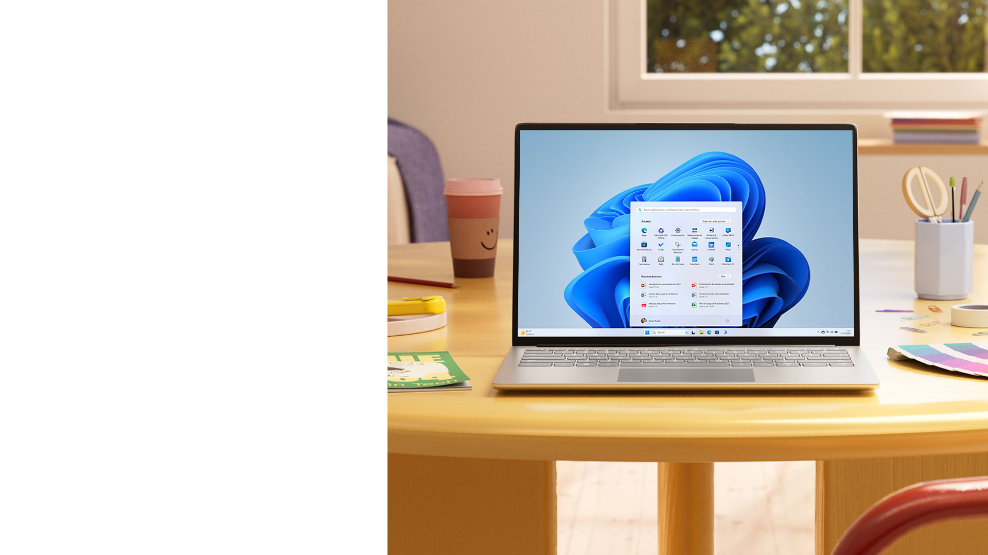 Una PC Windows 11 con el menú Inicio, sobre una mesa