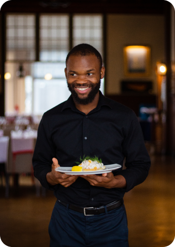 smiling waitor holding food