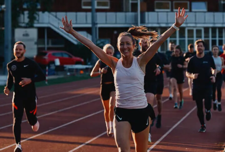 Girl running with hands up.