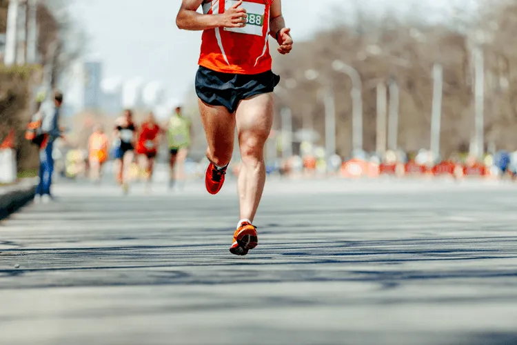 A man running down a street in a marathon..