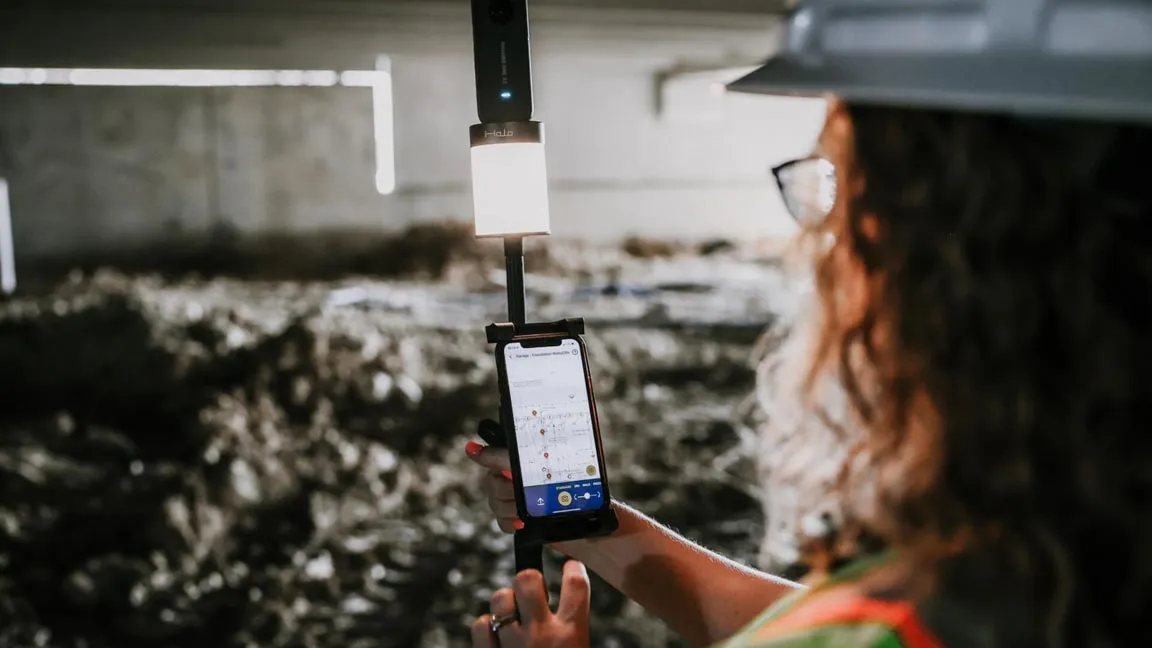 A construction worker looking at DroneDeploy on her phone