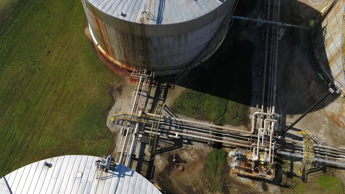 An aerial photo of two large buildings connected via piping