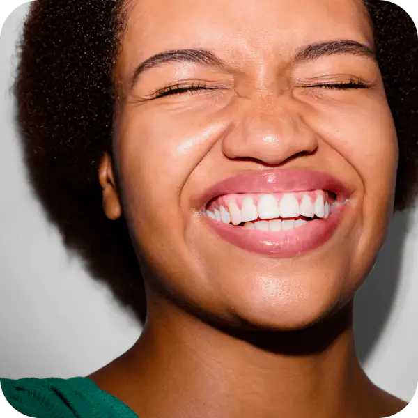 A woman smiling with her eyes closed.