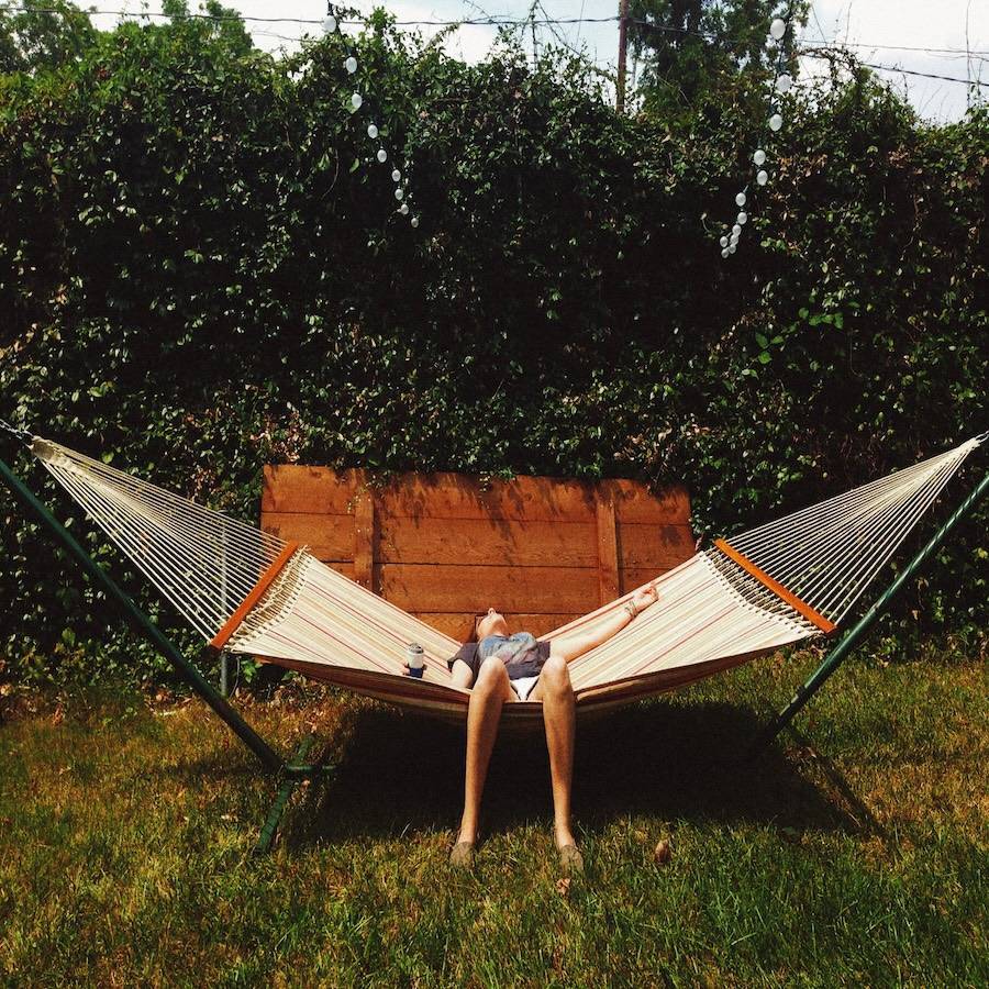 A person relaxing in a hammock in a backyard