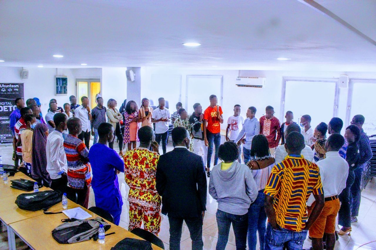 Large group of young adults standing in a circle and sharing