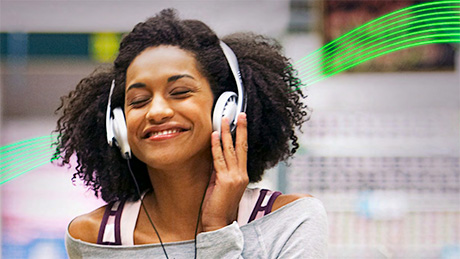 Woman enjoying listening to music through headphones