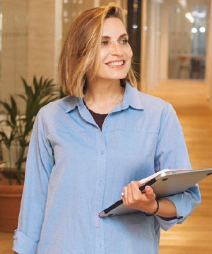 Woman holding laptop in office environment