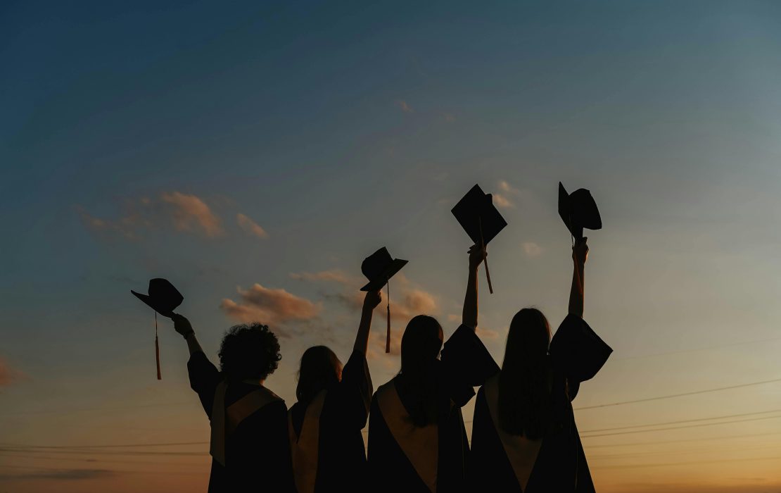 University graduates raising their caps in celebration 