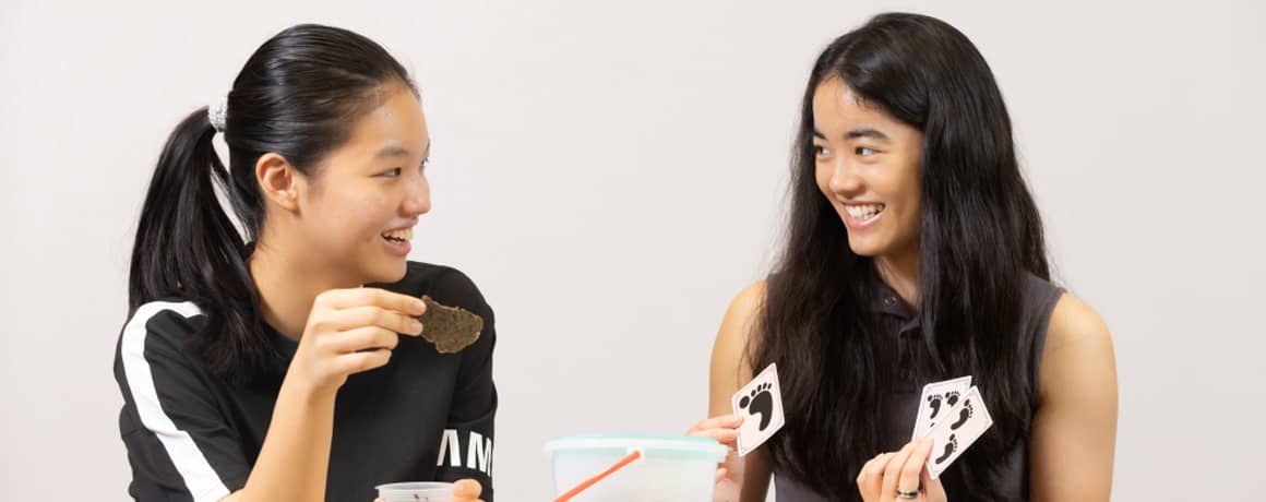 Two students holding the tea leaves