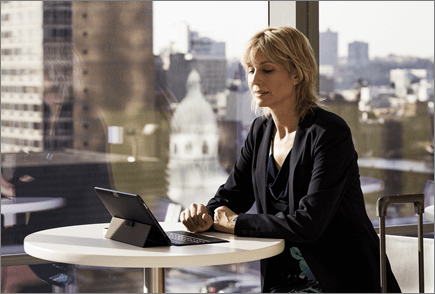 Vrouw op luchthaven die op een laptop werkt