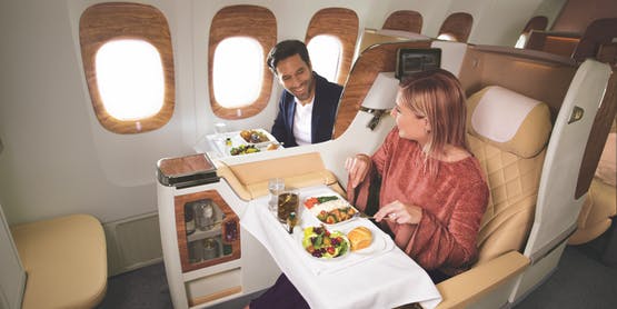 two passengers enjoying their meals in Emirates Boeing 777 Business Class