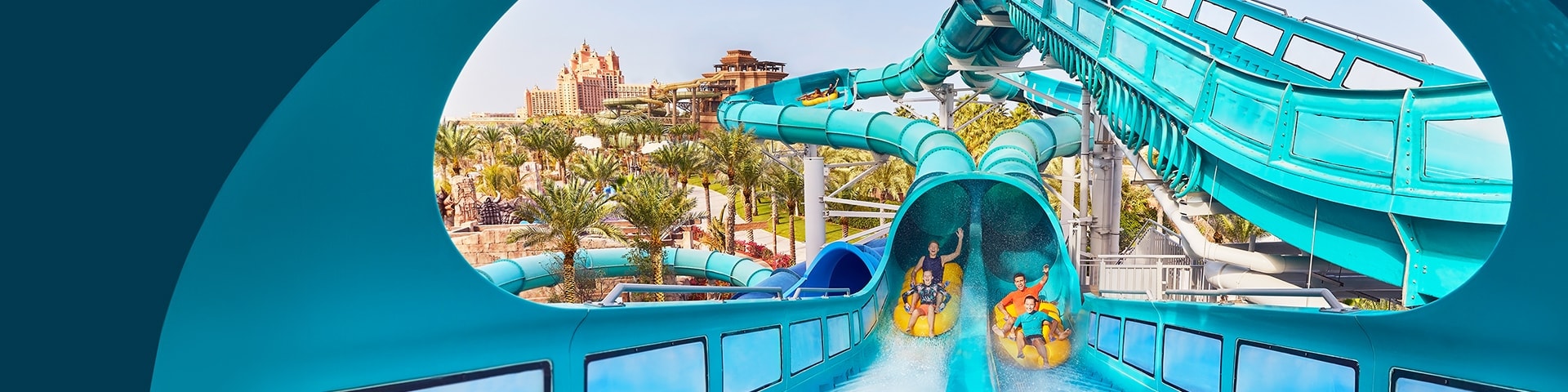 A family sliding down a blue water slide in aquaventure