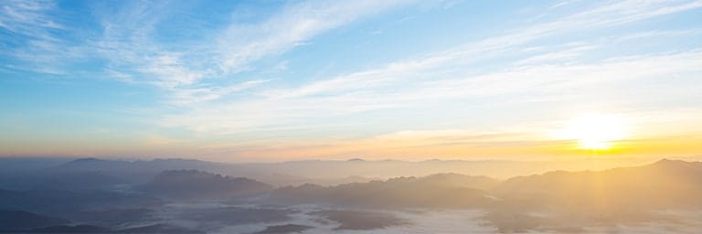 sunrise view of mountain summits above clouds