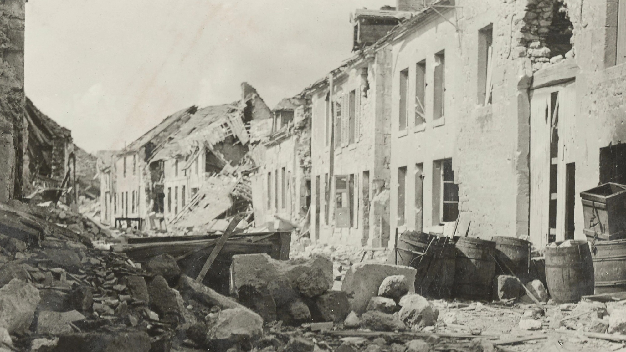 Rubble and debris litters a residential street. 