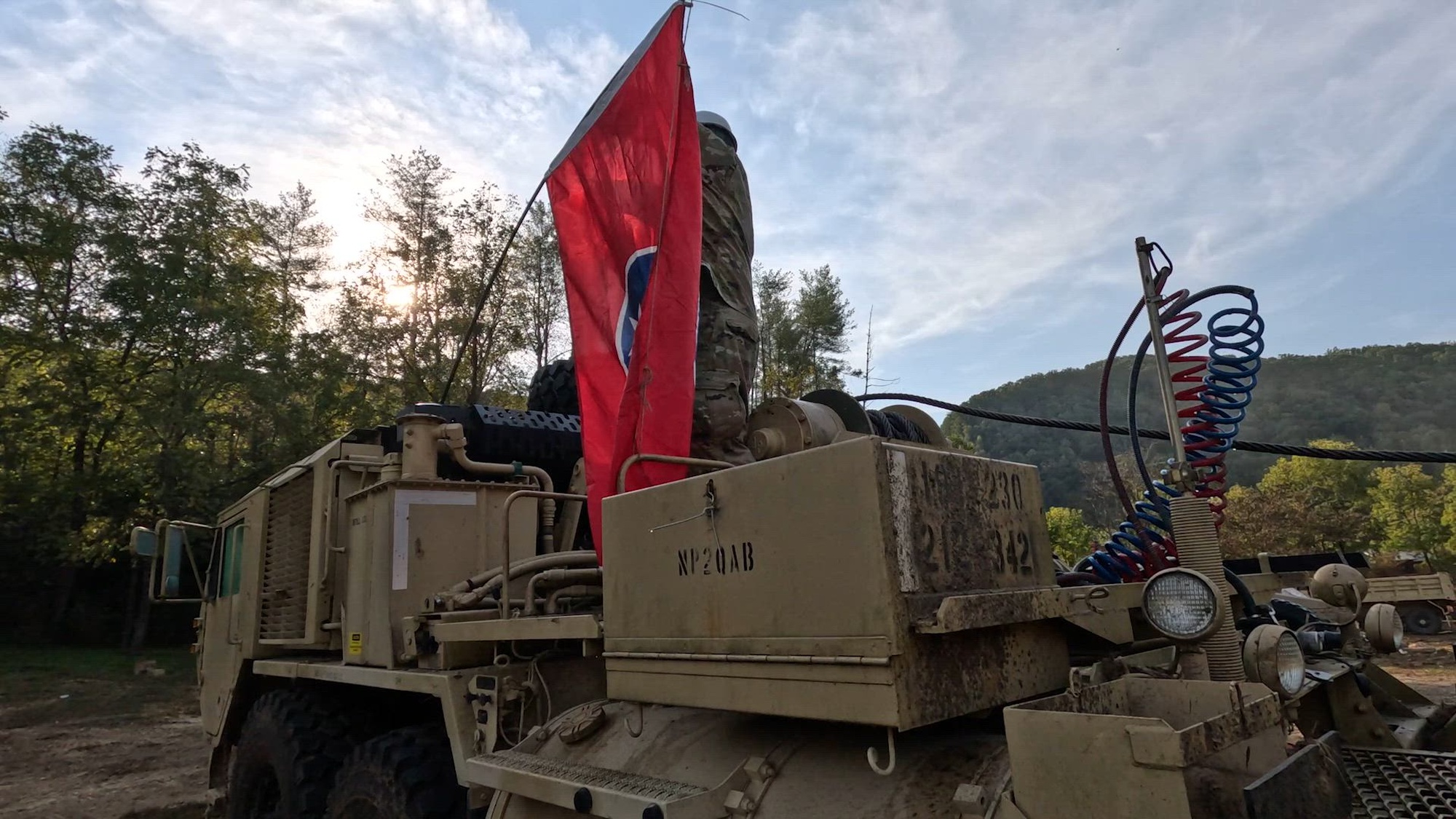 1st Lt. Robert Mehlhorn of the 230th Engineer Battalion, Tennessee Army National Guard, explains why his team flies the Tennessee flag each day while working to remove Hurricane Helene flood and storm damage in Cocke County, Tennessee Oct. 13, 2024. The flag serves as a symbol of unity as they clear bridges to ensure structural soundness for inspection. Joint Task Force Castle, comprised of engineers from the 230th Engineer Battalion, 134th Civil Engineer Squadron, 118th Civil Engineering Squadron, and 164th Civil Engineer Squadron, are using bulldozers, dump trucks, chainsaws, skid steer loaders, and other equipment to clear roads and other critical locations. They have already removed more than 420 truckloads of debris across several East Tennessee counties. (U.S. Air National Guard video by Staff Sgt. Yonette Martin)