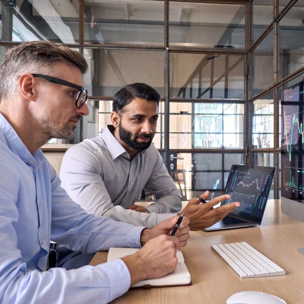 Two coworkers looking over data on their computer