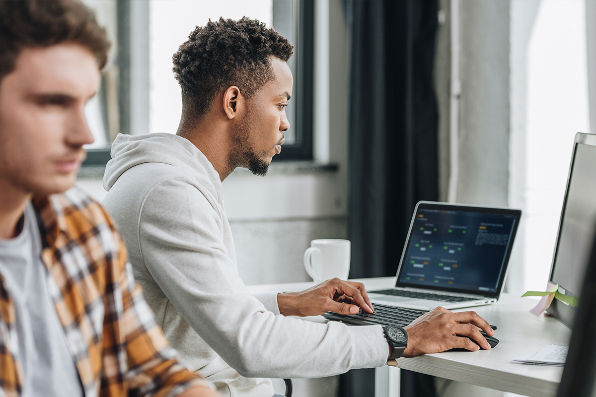 two men on laptops working