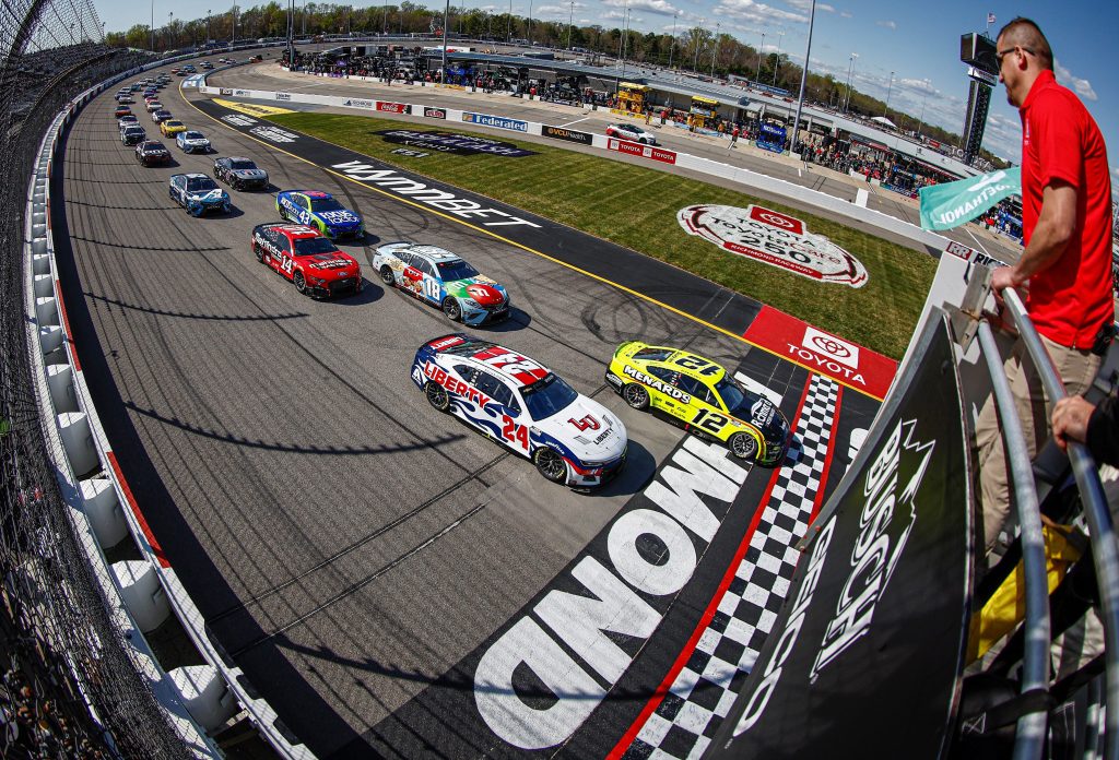 Photo of NASCAR race track with cars lined up at starting line