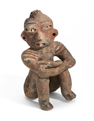 A clay figure depicting a man seated with his knees drawn up to his torso and his elbows resting on his knees.