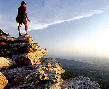 Hiker on top of mountain overlooking valley