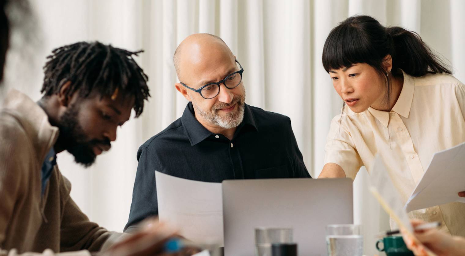 Three individuals looking over paperwork 