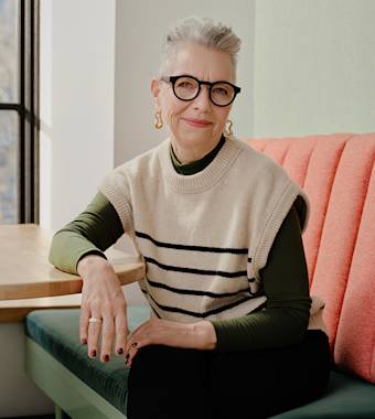 portrait shot of a creative-looking woman with gray short hair and large framed glasses 