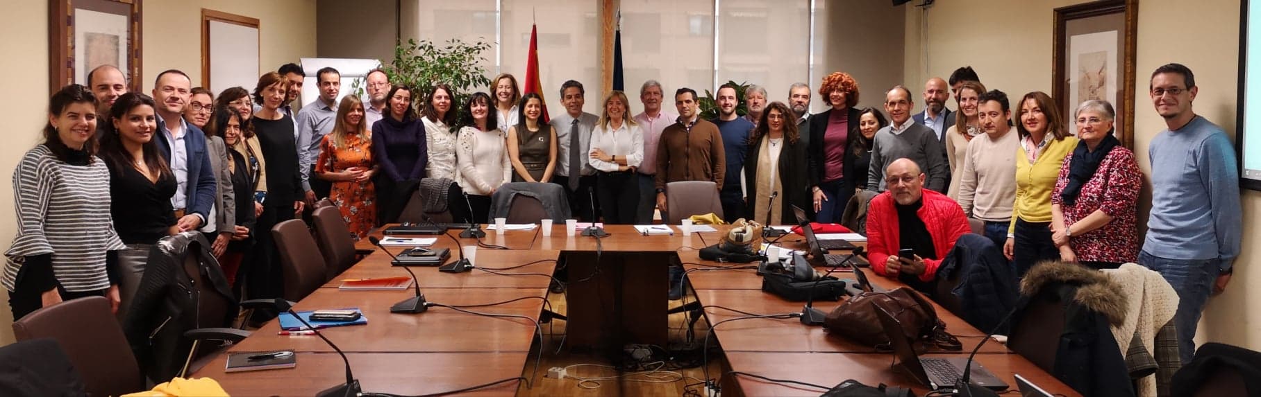 Image: Group of people posing for a picture in a meeting room around a table