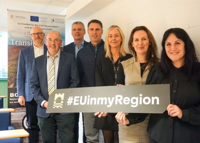 Photo from event called "Green Futures, Sustainable Innovation in the Midlands" showing a group of men and women holding a sign that says #EUinmyRegion