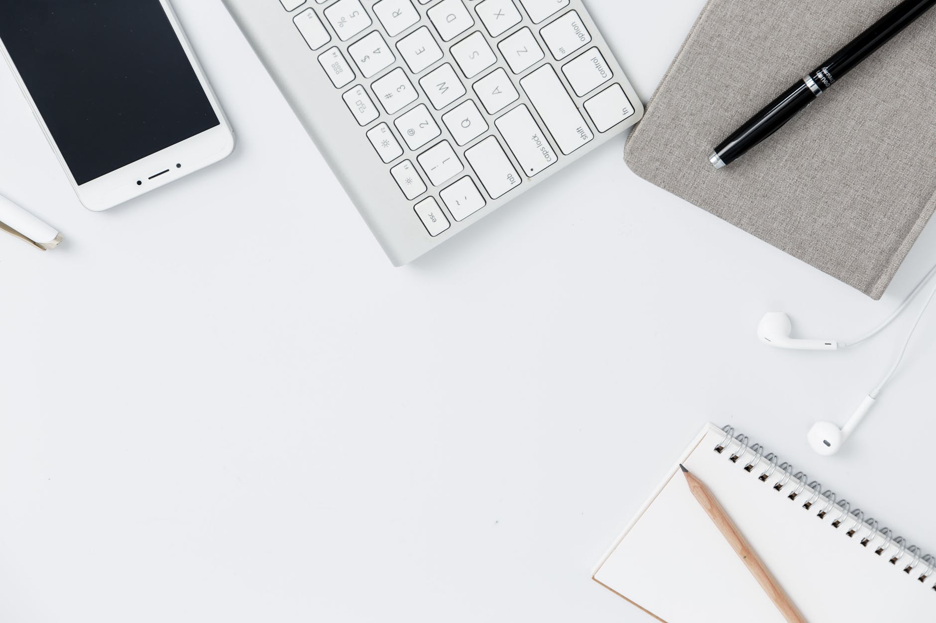 picture of office materials, keyboard, pencil, notebook and smartphone