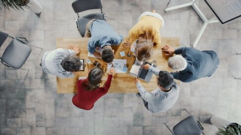 Photo of people having a meeting at a table, shot from above