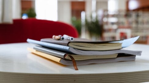 Notebooks on a table in a library - Alma