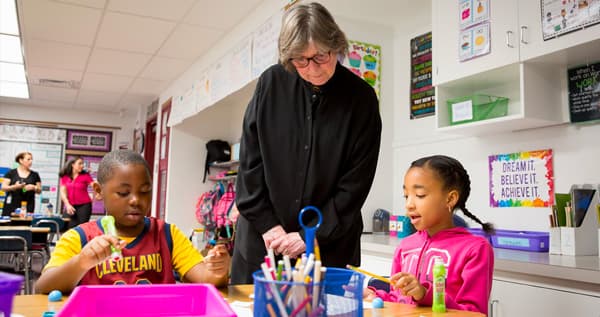 A teacher working with two children in a classroom