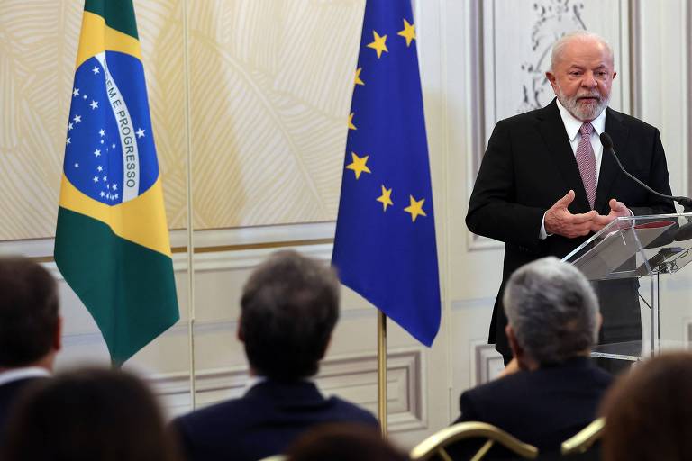 Ao lado das bandeiras do Brasil e da União Europeia, o presidente Lula discursa diante de jornalistas no dia seguinte ao encerramento da cúpula Celac-UE em Bruxelas, na Bélgica