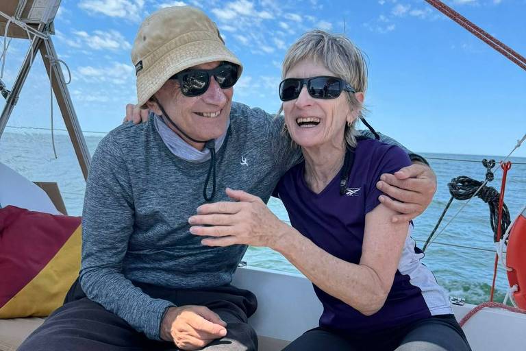 casal sentado em um veleiro no mar