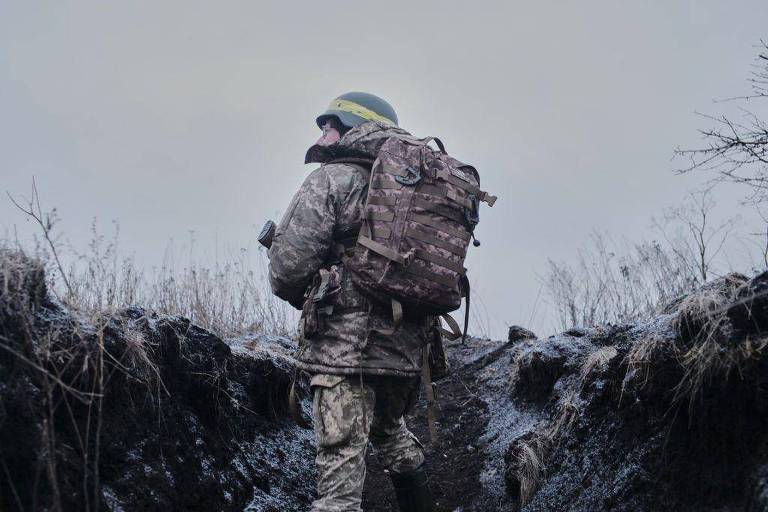 Soldado de costas observa área de mata